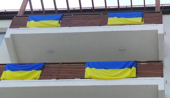 Украинские флаги с траурными лентами в Олимпийской деревне